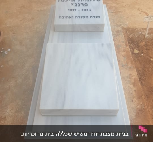 מצבה לבנה עם כיתוב בעברית ותאריכים